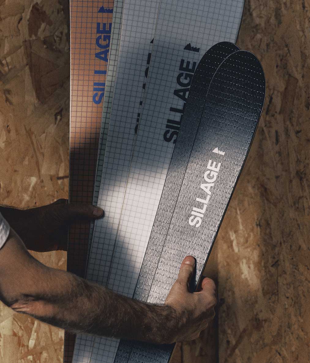 Une paire de skis Sillage tenue en main à l'atelier